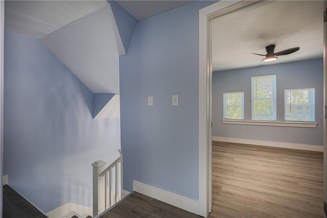 stairs with wood-type flooring and ceiling fan