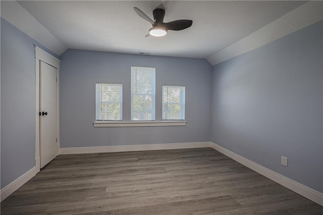 empty room with wood-type flooring, ceiling fan, and vaulted ceiling