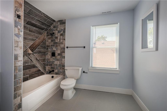 bathroom featuring tiled shower / bath, tile patterned floors, and toilet