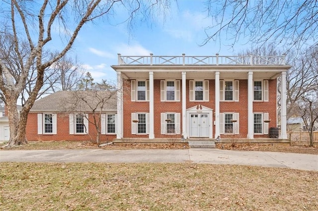 neoclassical home with brick siding and a front yard