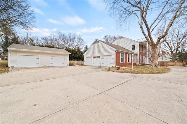 view of home's exterior featuring a garage, fence, and brick siding