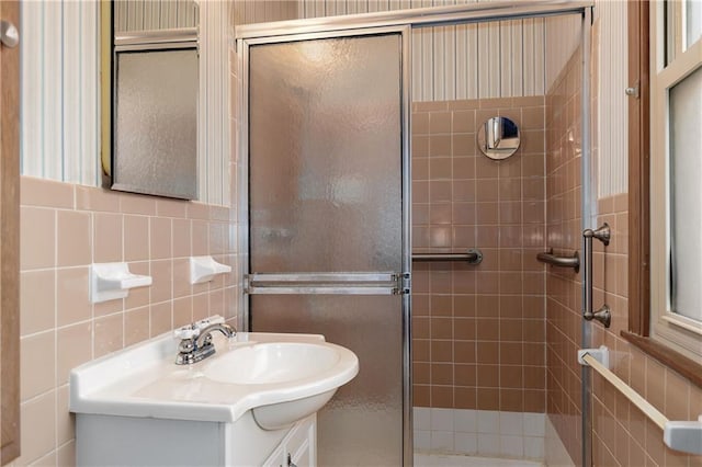 bathroom featuring vanity, tile walls, and a shower with shower door