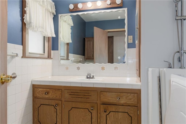 bathroom featuring vanity and tile walls