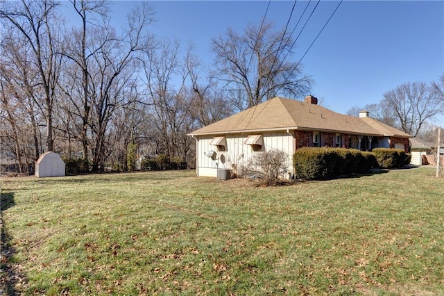 view of side of property with a yard and a shed