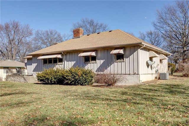 back of property featuring a yard and central air condition unit