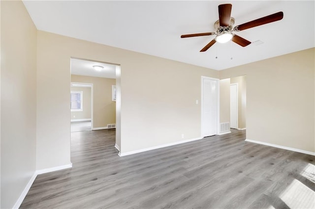 empty room with ceiling fan and light hardwood / wood-style flooring