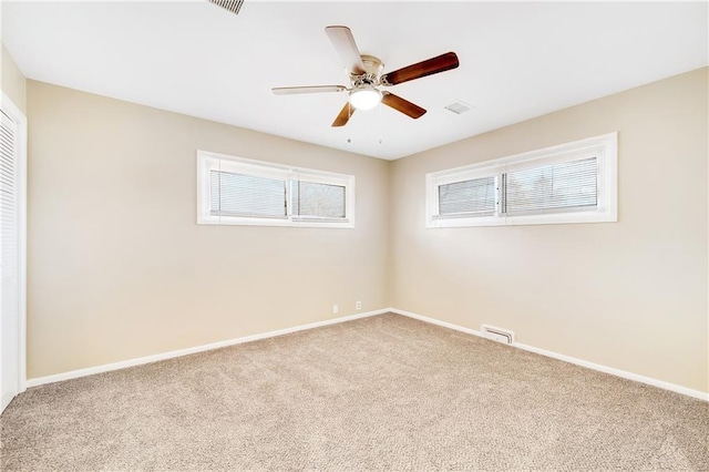 carpeted spare room with ceiling fan