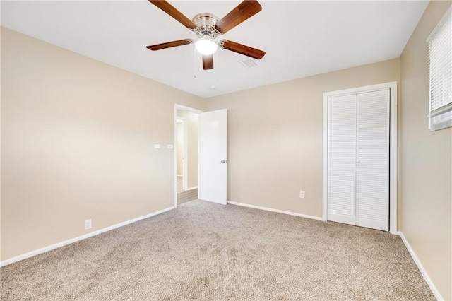 unfurnished bedroom with light colored carpet, ceiling fan, and a closet