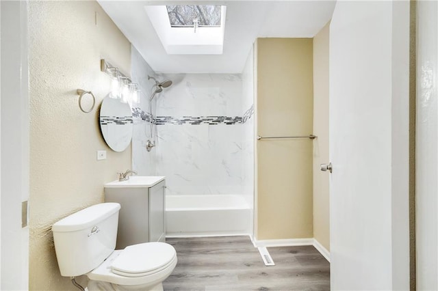 bathroom with vanity, hardwood / wood-style floors, a skylight, and toilet