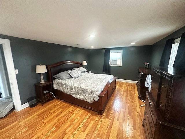 bedroom with baseboards, cooling unit, and light wood-style floors