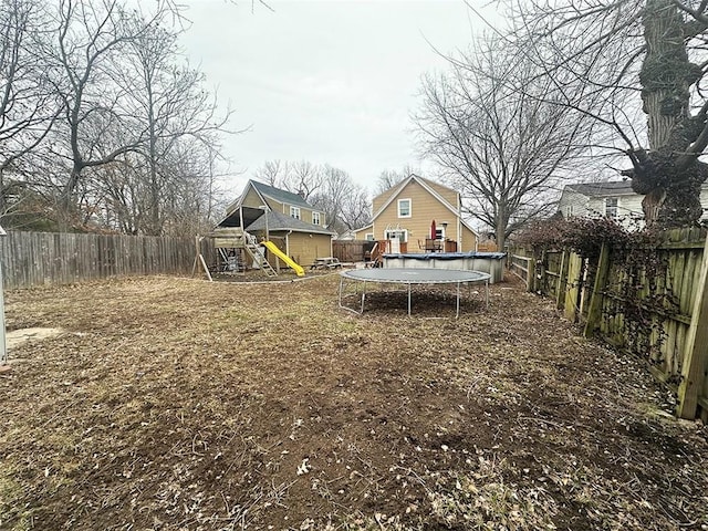 view of yard with a fenced in pool, a fenced backyard, a trampoline, and a playground