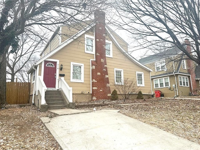 view of front of home with a chimney and fence