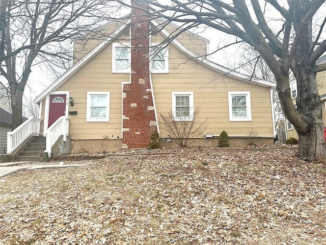 view of front of home with entry steps and a chimney