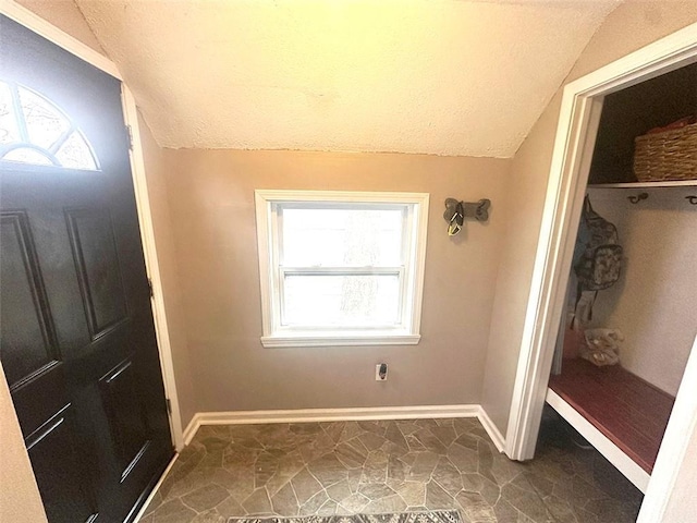 mudroom with vaulted ceiling, baseboards, and a healthy amount of sunlight