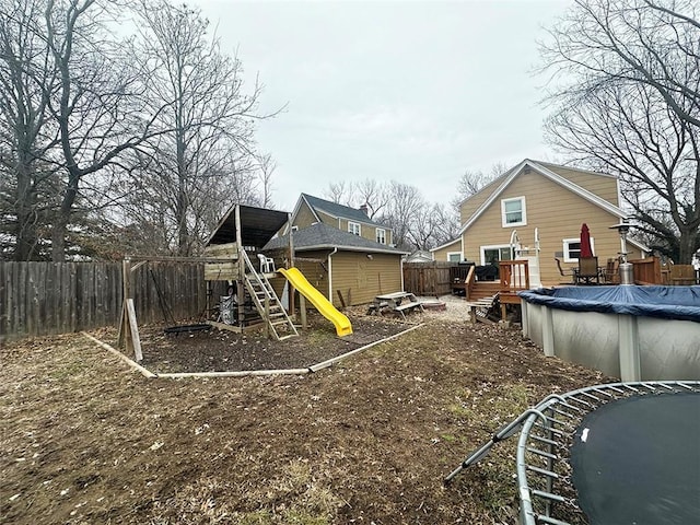 view of yard with a fenced backyard, a playground, a deck, and a fenced in pool