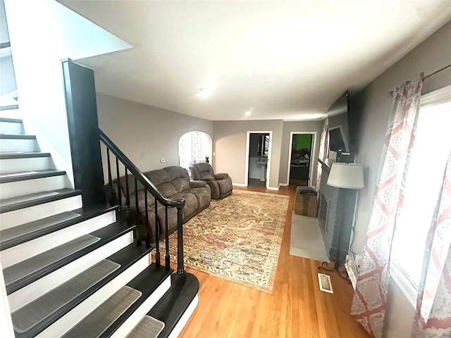 living area featuring stairs, wood finished floors, and visible vents