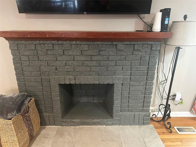 details featuring visible vents, a fireplace, and wood finished floors