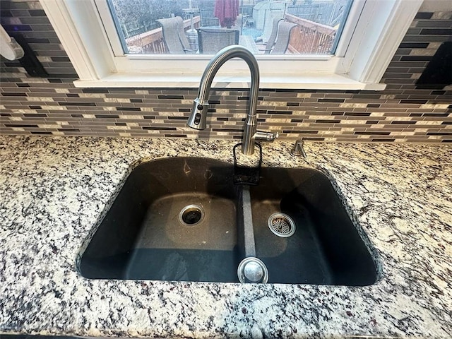 details with stone counters, white cabinets, and a sink