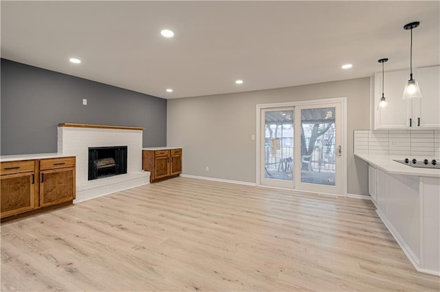 living room with a brick fireplace and light hardwood / wood-style flooring