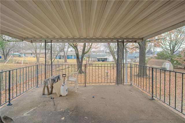 view of patio with a playground and a shed