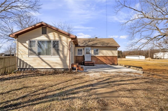 rear view of house with a patio area and a lawn