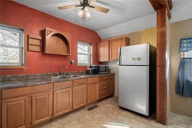 kitchen featuring vaulted ceiling, ceiling fan, appliances with stainless steel finishes, and sink