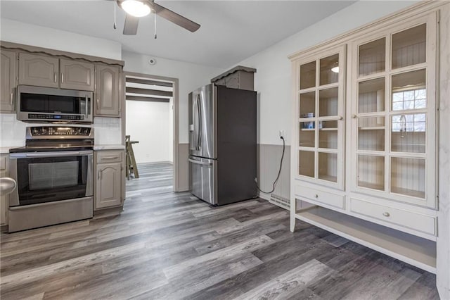 kitchen with decorative backsplash, dark wood-type flooring, ceiling fan, and appliances with stainless steel finishes