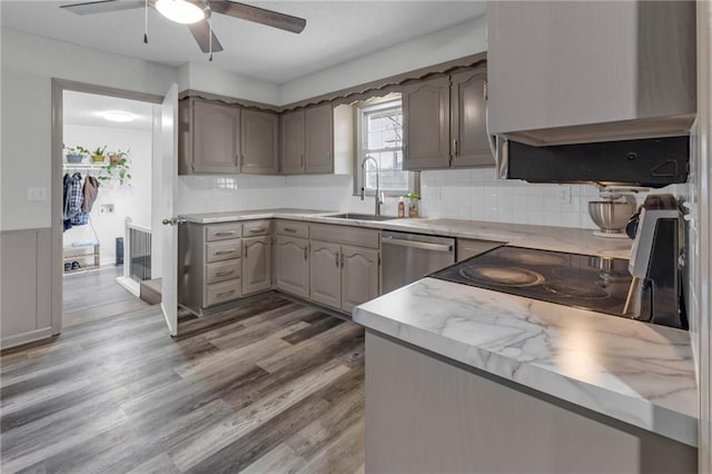 kitchen with dishwasher, sink, decorative backsplash, hardwood / wood-style flooring, and ceiling fan