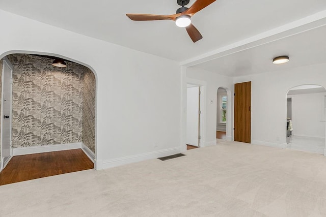 spare room with ceiling fan and light colored carpet