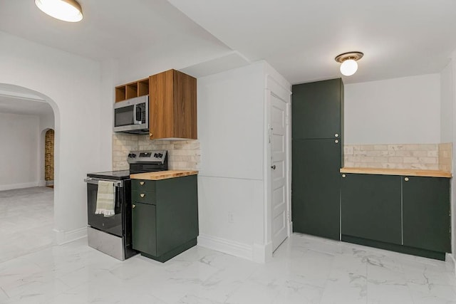 kitchen featuring appliances with stainless steel finishes, backsplash, and wood counters