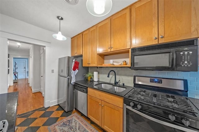 kitchen featuring pendant lighting, appliances with stainless steel finishes, sink, and decorative backsplash