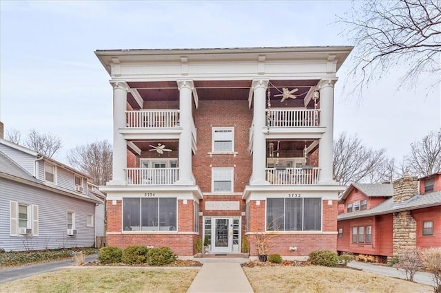 view of front of house featuring a balcony and ceiling fan