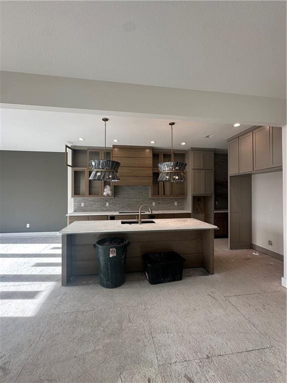 kitchen with a large island, decorative light fixtures, sink, and tasteful backsplash