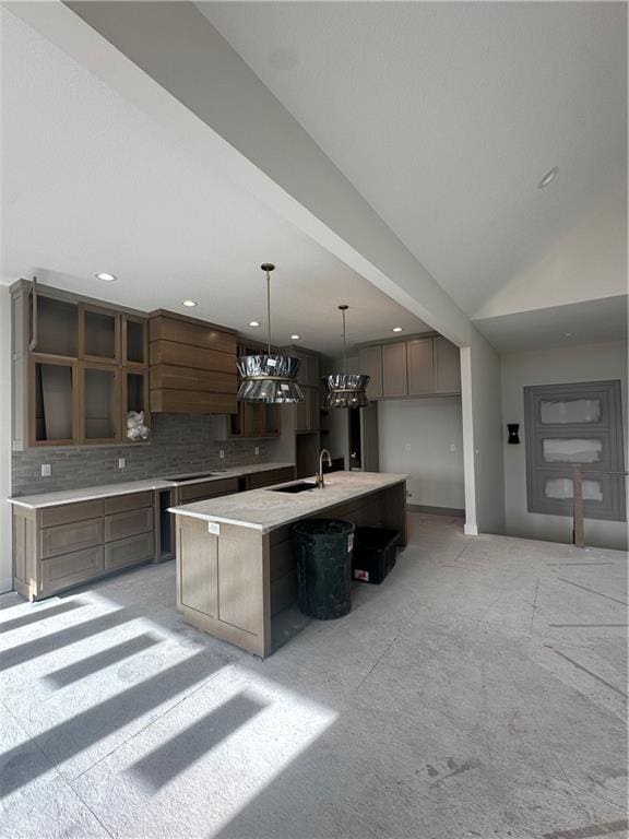 kitchen featuring a large island, sink, stovetop, backsplash, and decorative light fixtures