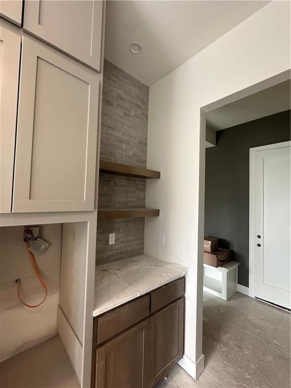 interior space with light stone counters and decorative backsplash