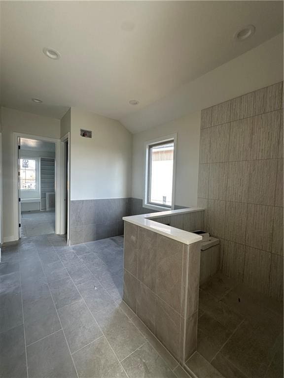 bathroom with lofted ceiling and tile patterned flooring