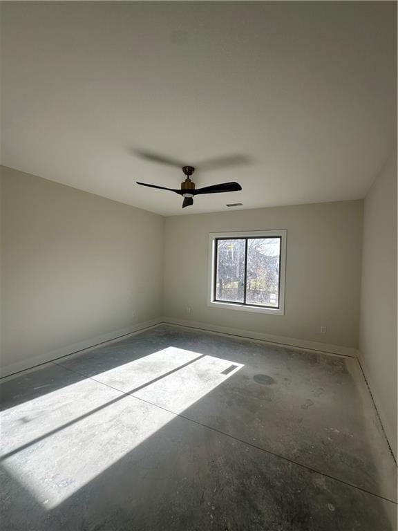 unfurnished room featuring ceiling fan and concrete floors