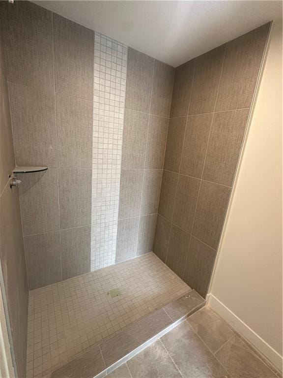 bathroom with tile patterned flooring and a tile shower