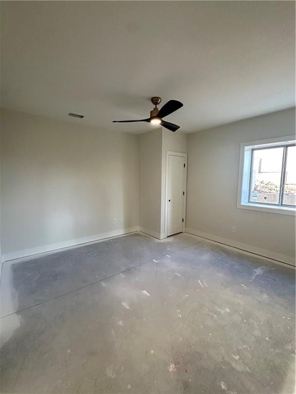 empty room with concrete flooring and ceiling fan