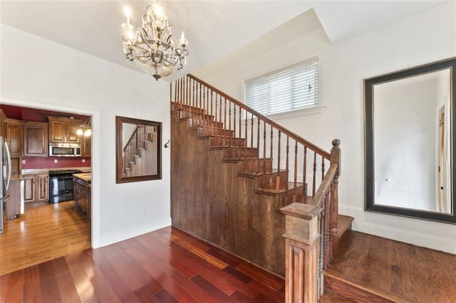 stairway featuring hardwood / wood-style flooring and a chandelier