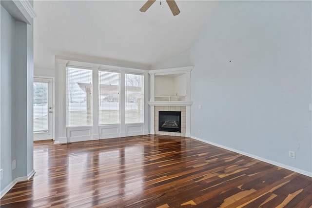 unfurnished living room with dark wood-type flooring, ceiling fan, high vaulted ceiling, and a tile fireplace