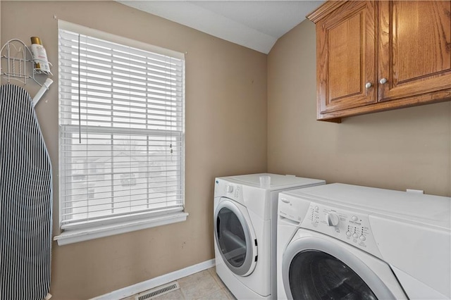 laundry area featuring cabinets, light tile patterned flooring, and independent washer and dryer