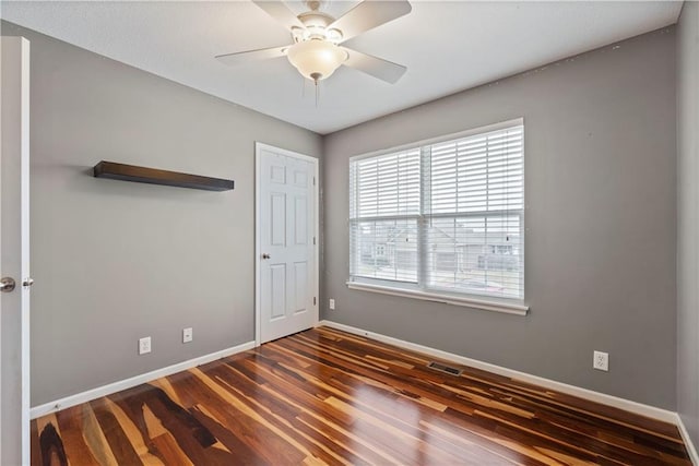 empty room featuring dark hardwood / wood-style floors and ceiling fan