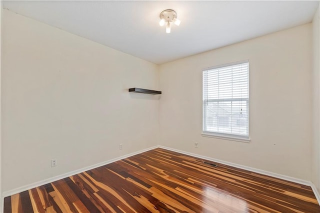 spare room featuring dark wood-type flooring