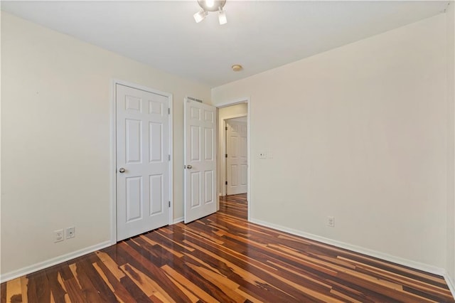 unfurnished bedroom with dark hardwood / wood-style flooring