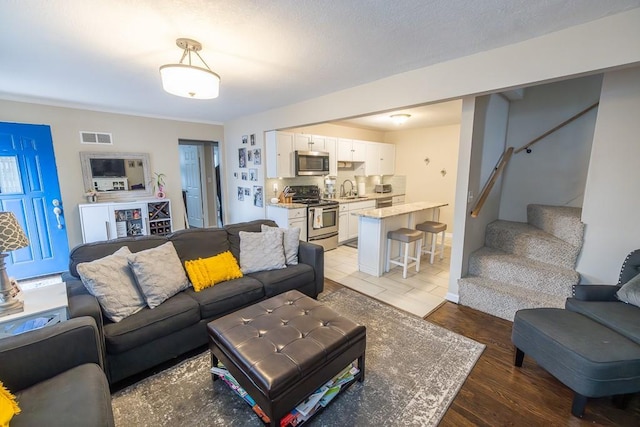 living room featuring sink and light hardwood / wood-style flooring