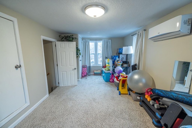 rec room featuring a wall mounted air conditioner and a textured ceiling