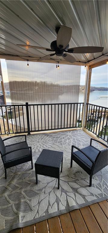 view of patio / terrace featuring ceiling fan, a balcony, and a water view