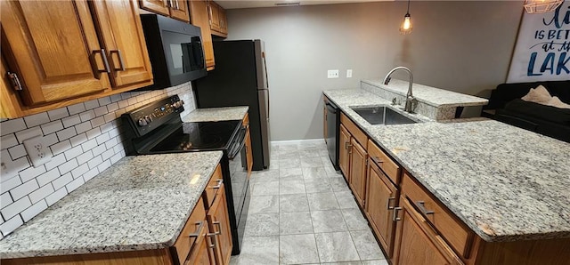 kitchen with sink, backsplash, hanging light fixtures, black appliances, and light stone countertops