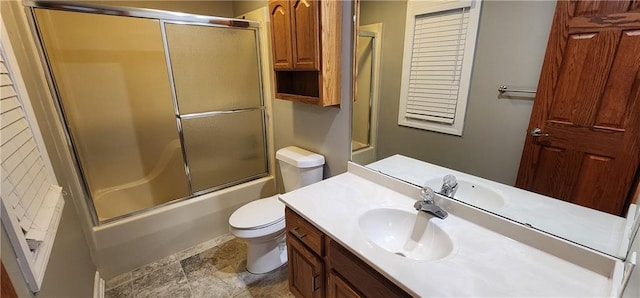 full bathroom featuring enclosed tub / shower combo, vanity, and toilet